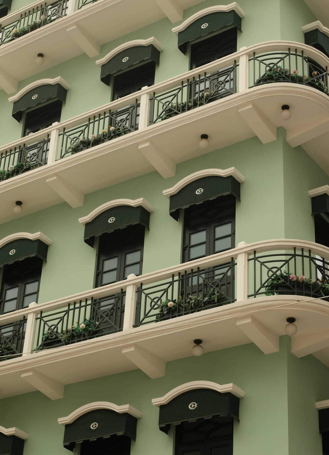 Fassade eines Mehrfamilienhauses mit Balkonen und geschlossenen Fensterläden